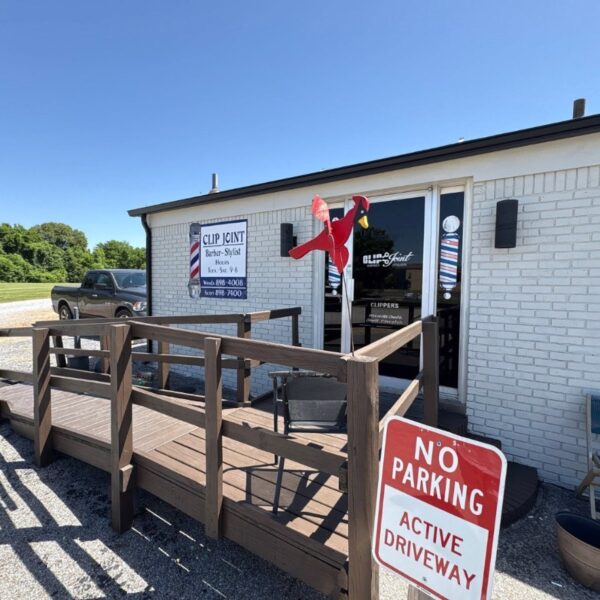 Clip Joint barbershop exterior painted white with a wooden ramp