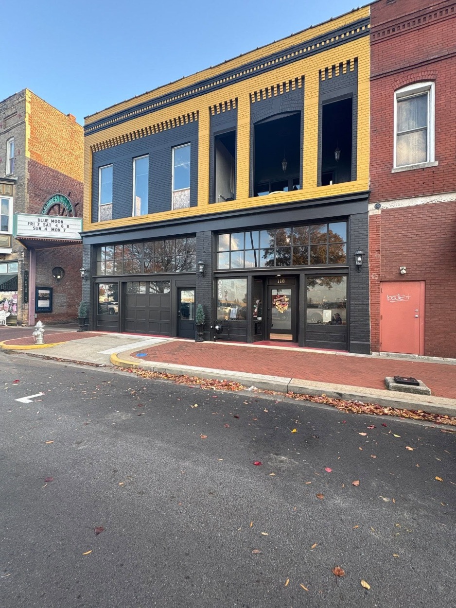 Downtown brick storefront painted black with yellow trim