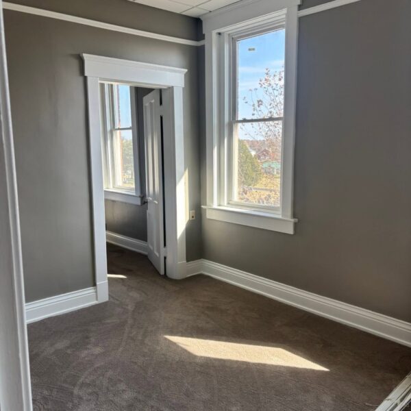 Empty office room with freshly painted gray walls and white trim