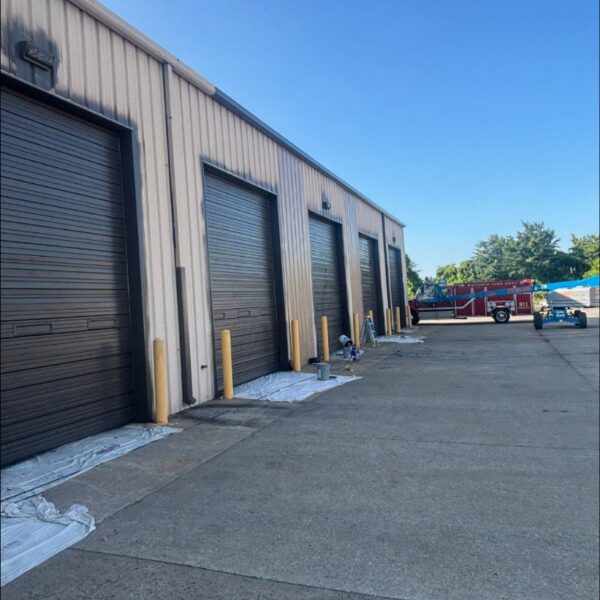 Fire station garage bay doors and tan metal walls freshly painted