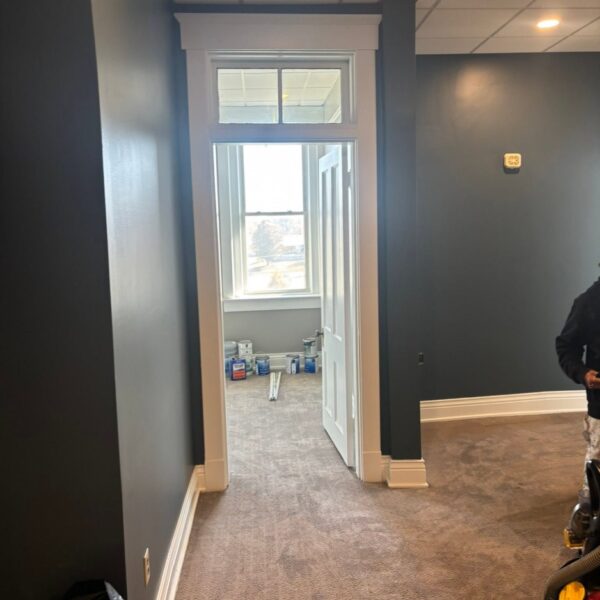 Office Hallway In Progress Office hallway mid repaint with paint cans and dark blue gray walls