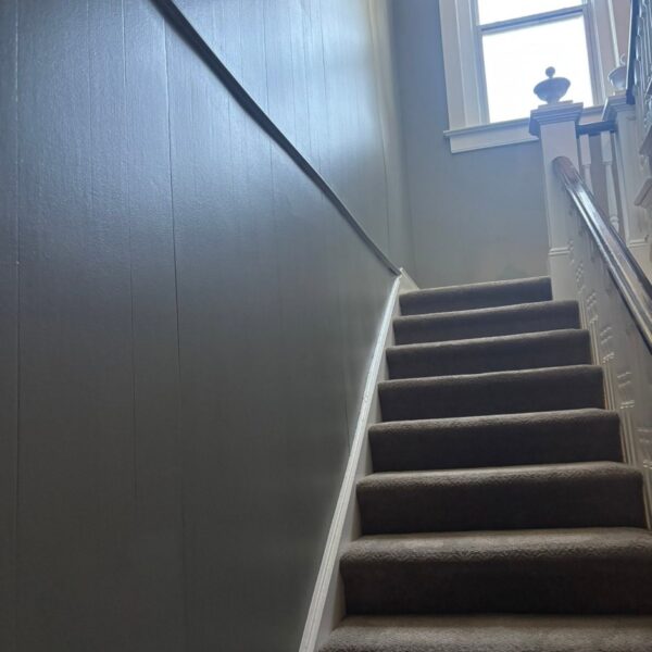 Office stairwell with blue gray walls and painted wainscoting