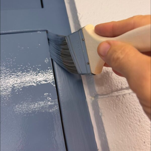 Painter at Work Rodgers Painting painter brushing blue paint onto a trim board