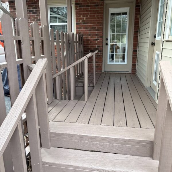 Stained Porch Steps Stained wooden porch steps and railing leading to a brick home’s back door